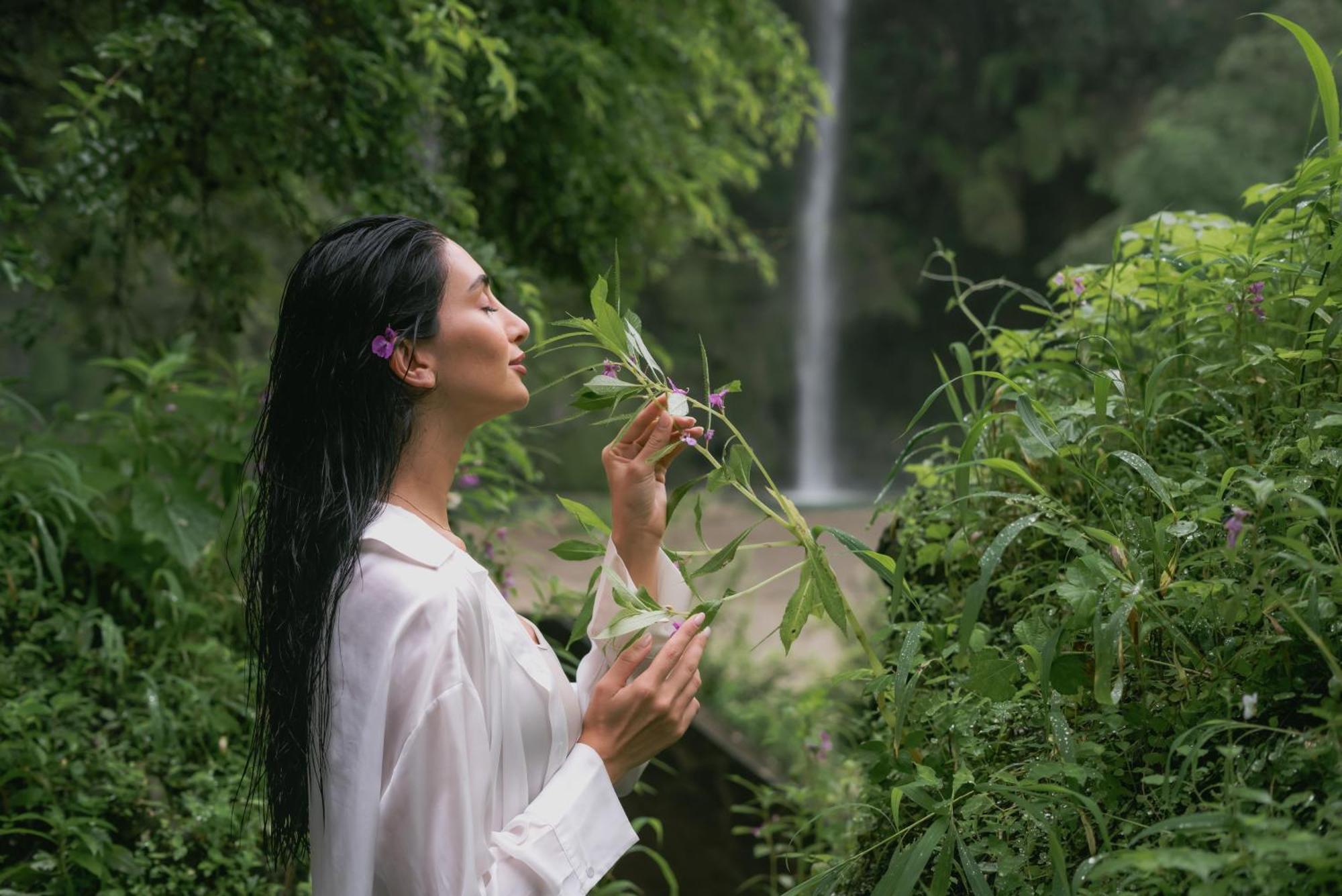 Salalah Rotana Resort Exteriér fotografie A woman smelling flowers